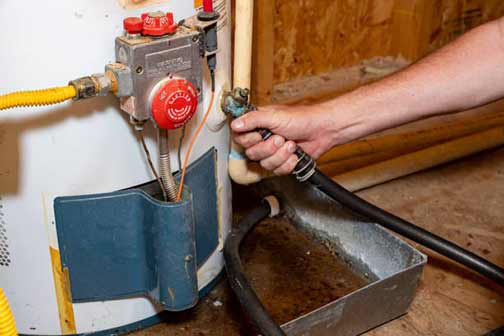 a man flushing out his water heater
