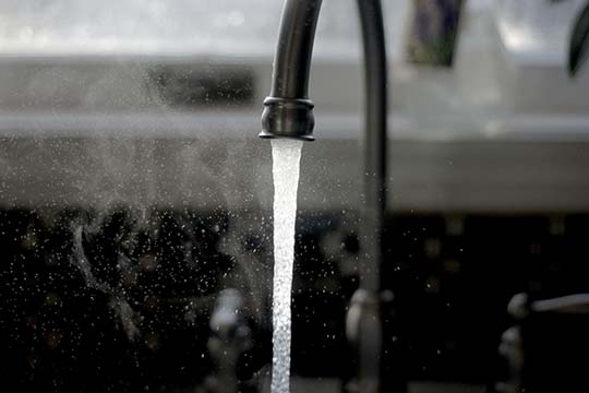 Steaming hot water from a faucet.