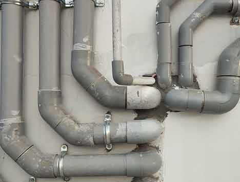 Gray pipes connecting to a wall.
