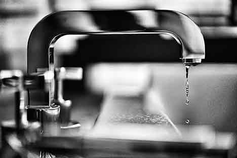 black and white photo of a dripping faucet