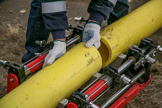 A plumber joining two parts of a pipe.