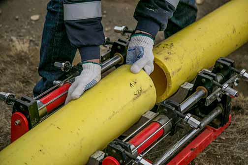 A man holding yellow pipes.