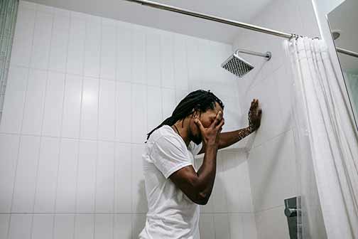 A man in a white shirt in a shower