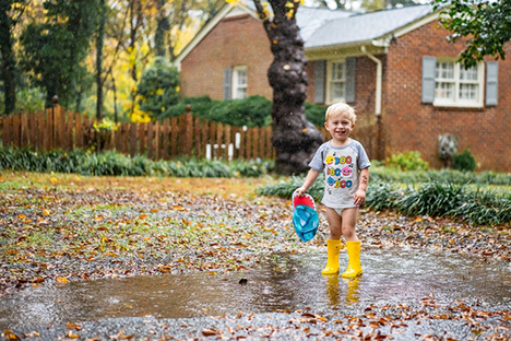 kid playing in puddles