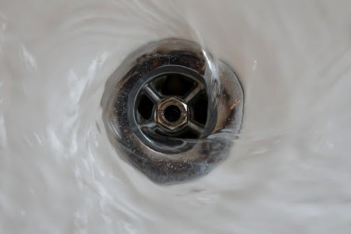 pouring hot water down the drain.