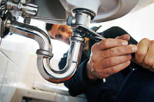 a plumber making repairs in an apartment.