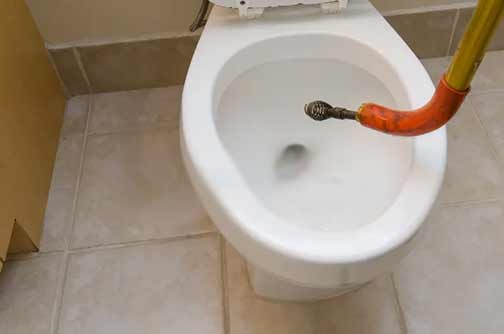 a person augering their toilet