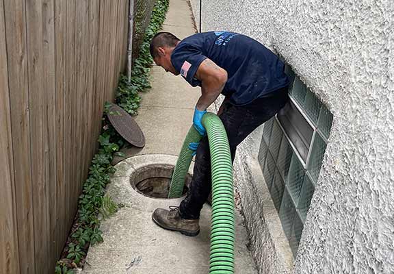 a plumber pumping out a catch basin in chicagoland