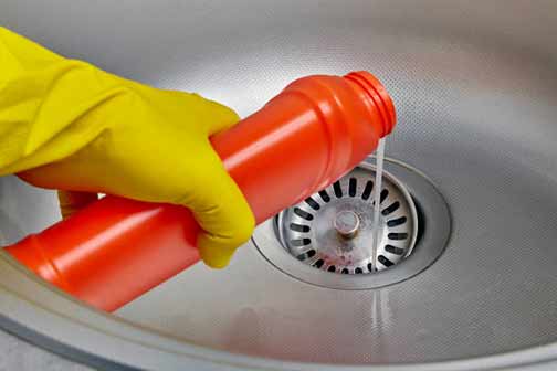 a person pouring chemical drain cleaner down drain