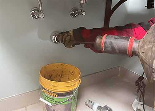 a professional plumber cleaning out a drain