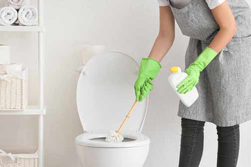 a woman cleaning her bathroom after flooding.