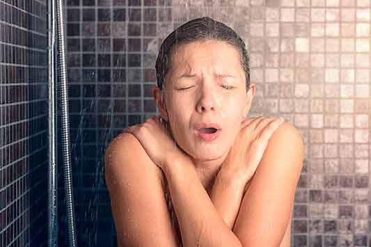 a woman not getting hot water in her shower.