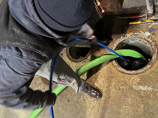 commercial plumbers in woodridge performing a drain cleaning service.