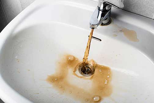 a bathroom faucet with dirty tap water