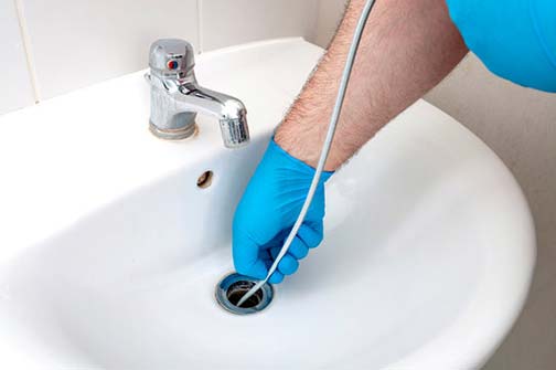 a plumber cleaning a drain in palos hills illinois