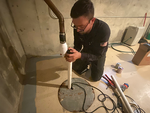 a professional plumber performing an ejector pump repair.