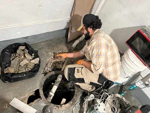 a plumber working on an ejector pump