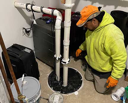 Ejector pump replacement in Chicago Illinois with technician servicing basement sewage pump system