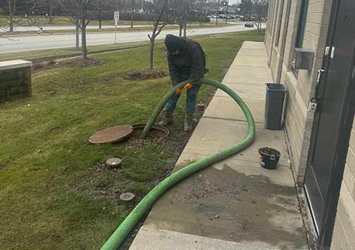 an emergency plumber performing an emergency drain cleaning service