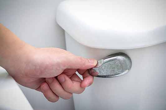 a person trying fix a toilet that won't stop flushing.