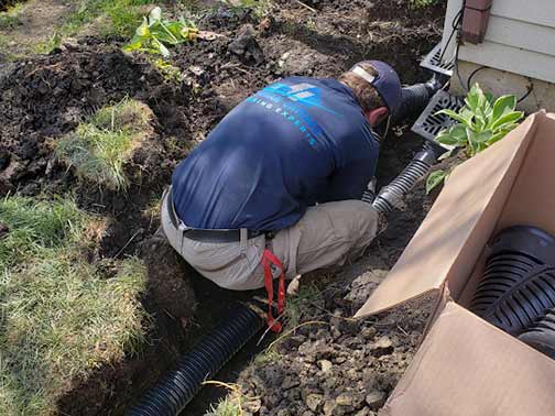 a professional installing a french drain system