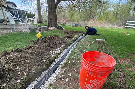 French drain installation Naperville Illinois residential drainage system protecting yard from flooding