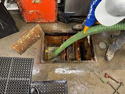 Grease trap cleaning in Chicago Illinois with technician servicing commercial grease system