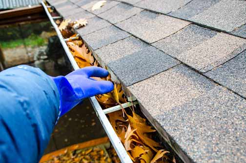 a man cleaning out his gutters