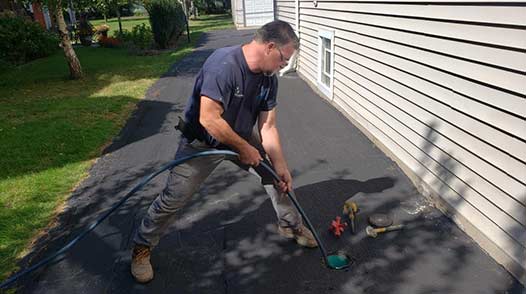 a plumber performing a hydro jet drain cleaning for a customer.