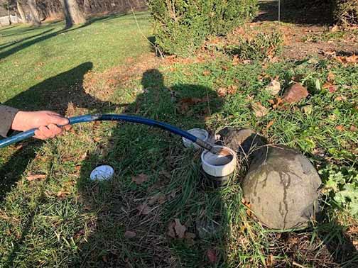 a man using hydro jetting to clear a sewer clog.