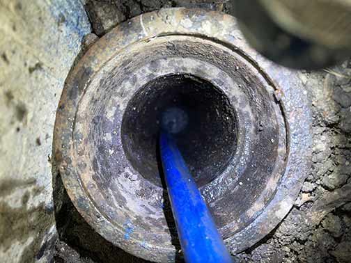 hydro jetting a garage floor drain to remove a clog.