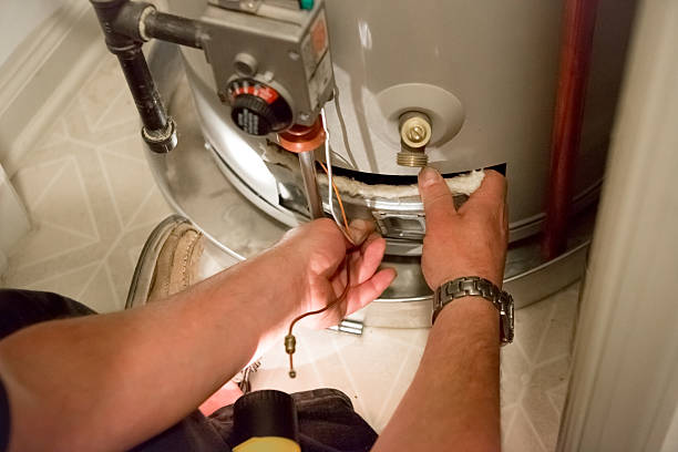 plumber performing water heater maintenance.