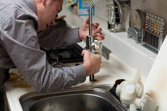 a person installing a kitchen sink