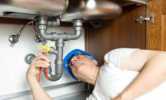 a plumber fixing leaking pipes