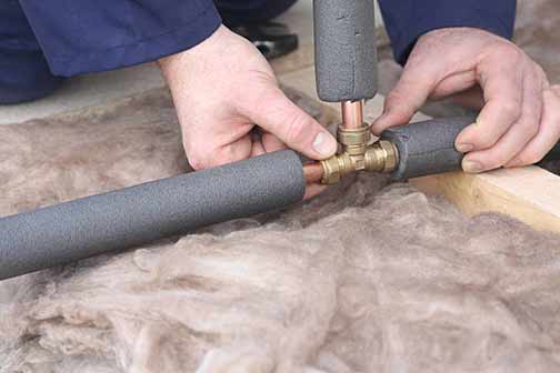 a man putting pipe insulation over his pipes