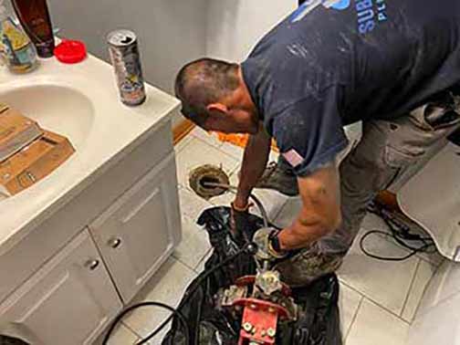 a plumber performing an emergency drain cleaning