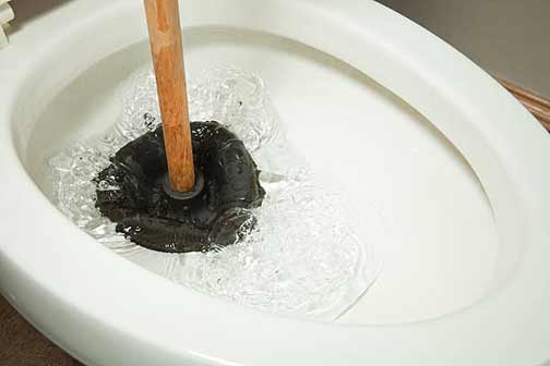 a person plunging a toilet