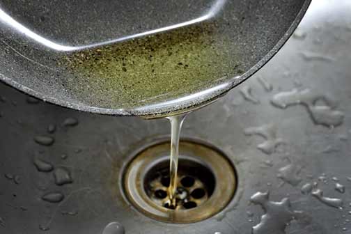 a person pouring grease down their drain