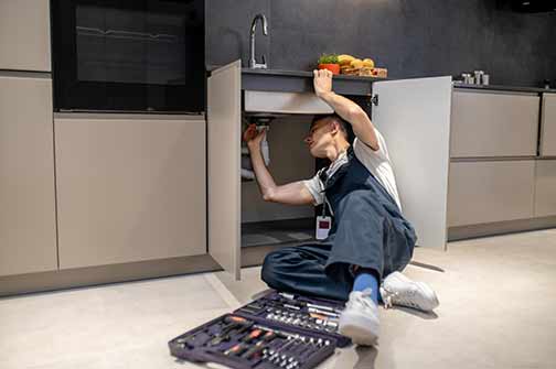 a professional plumber making repairs in a home.