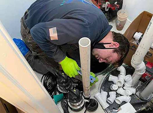 a plumber upgrading and replacing a sump pump.