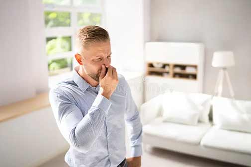 a man smelling odors from his septic tank