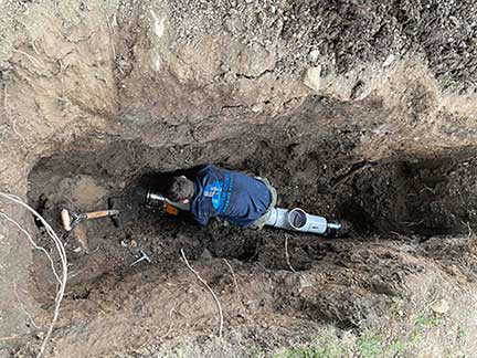 Sewer line repair in Chicago Illinois exposing damaged underground sewer pipe during repair