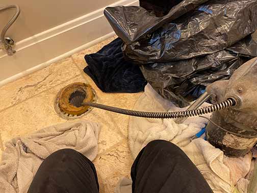 a plumber using sewer rodding to clear a toilet clog in hinsdale il.