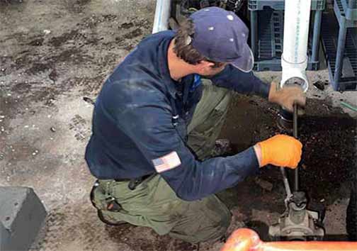 a commercial plumber performing a sewer rodding at a business.