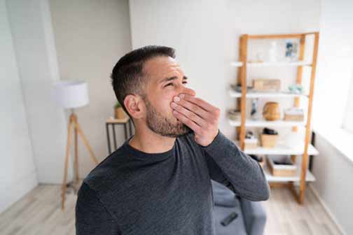 a man catching a whiff of his smelly ejector pump