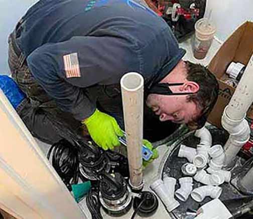 a plumber installing a sump pump.