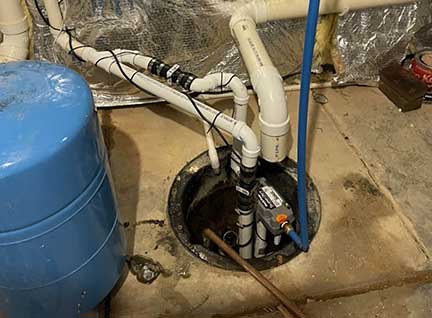 Sump pump replacement in Darien Illinois with technician installing basement pump system