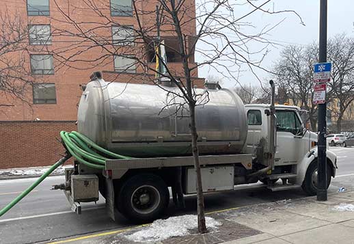 a vaccum pump truck service cleaning out a catch basin.