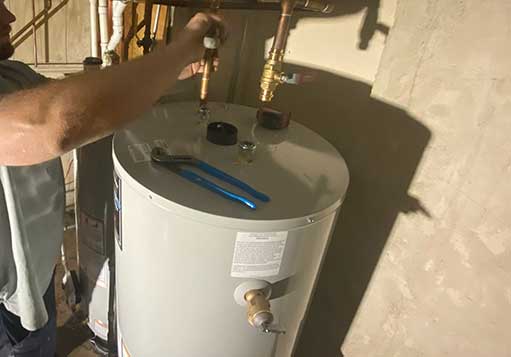 a plumber in the middle of a water heater installation in woodridge.