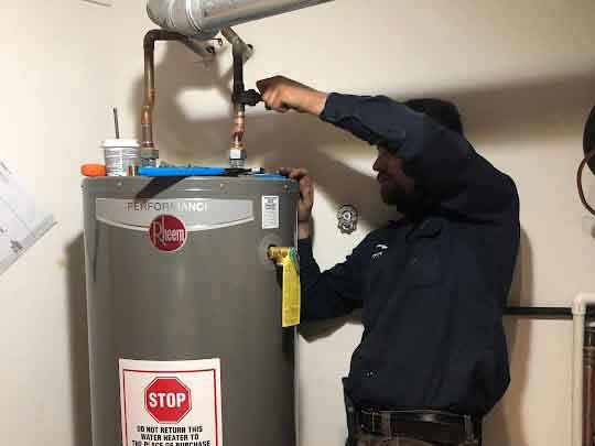 a licensed plumber installing a water heater tank